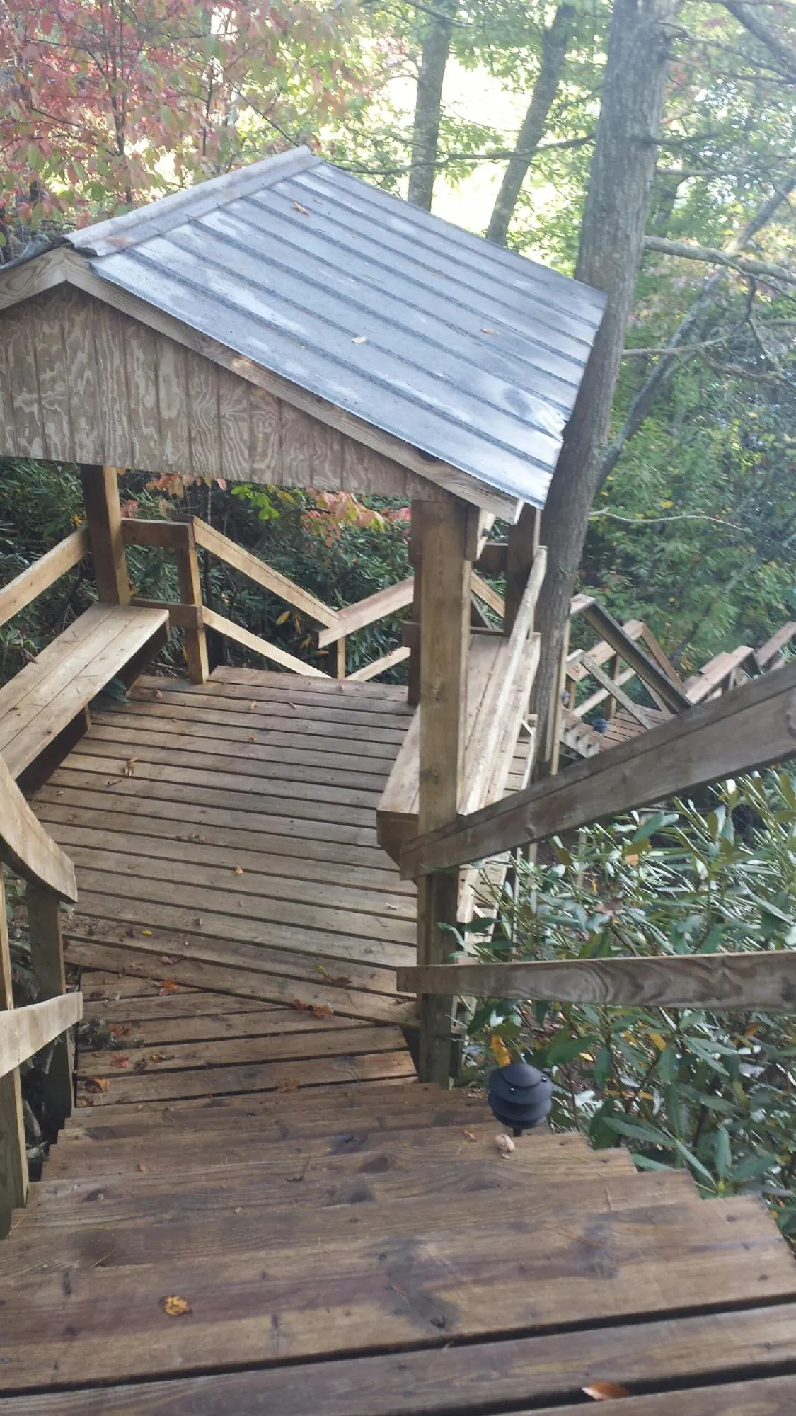 Metal roofed shelter over wooden steps on a wooded walkway — Skylight Repair & Installation work by our crew in Jefferson